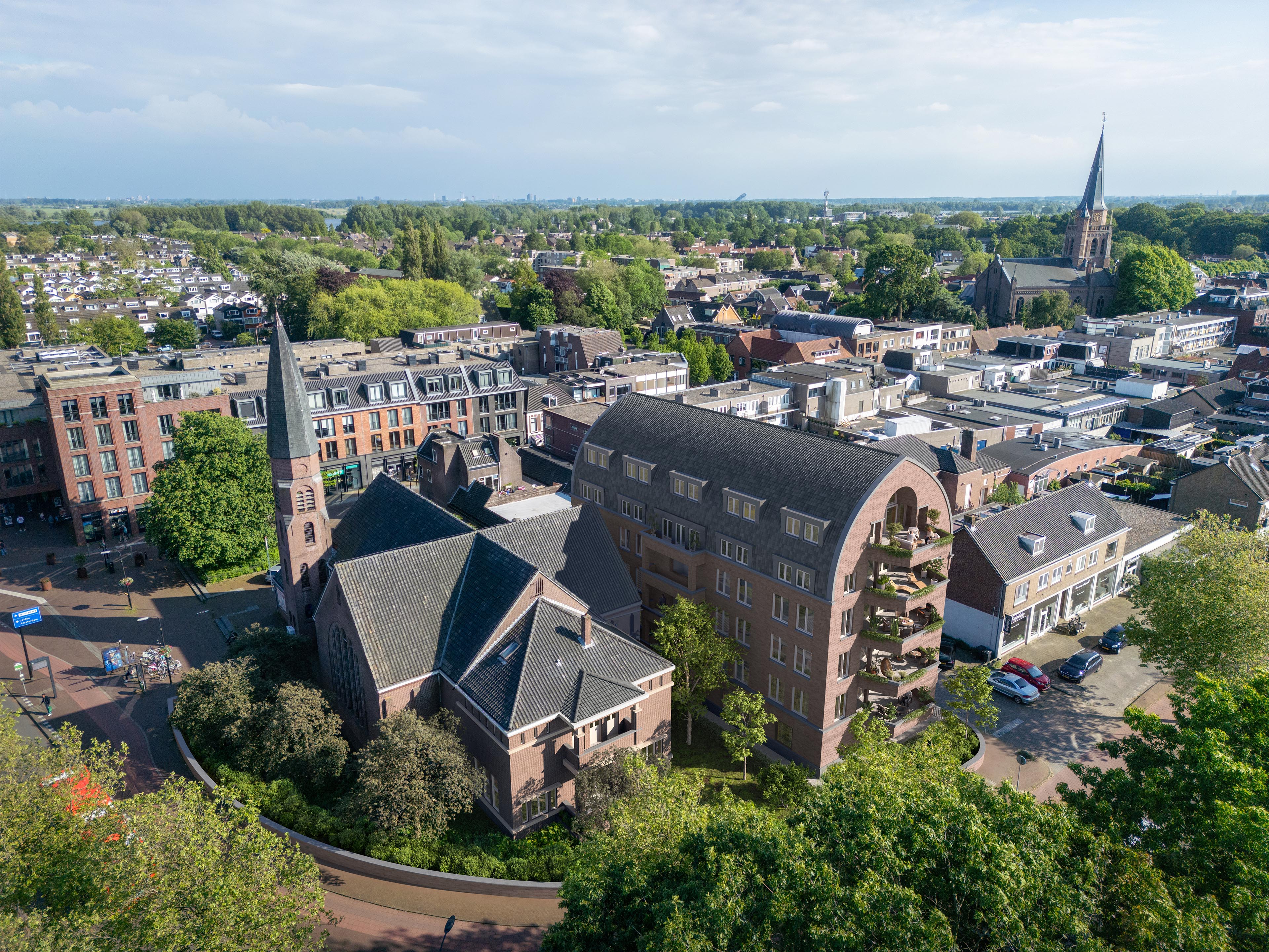 Aerial view of Kruispunt residential building beside a brick church in central Voorschoten