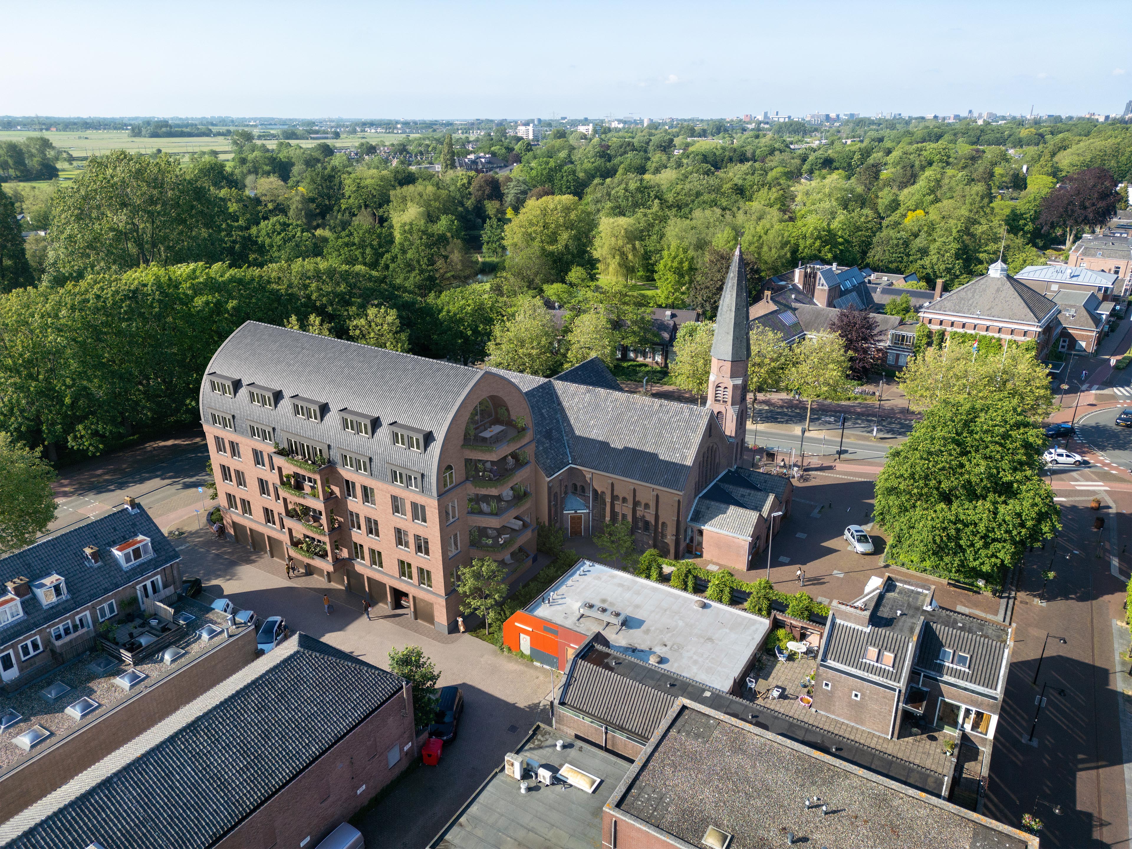 Elevated view of Kruispunt with brick façades, dormer windows, and planted balconies beside a church