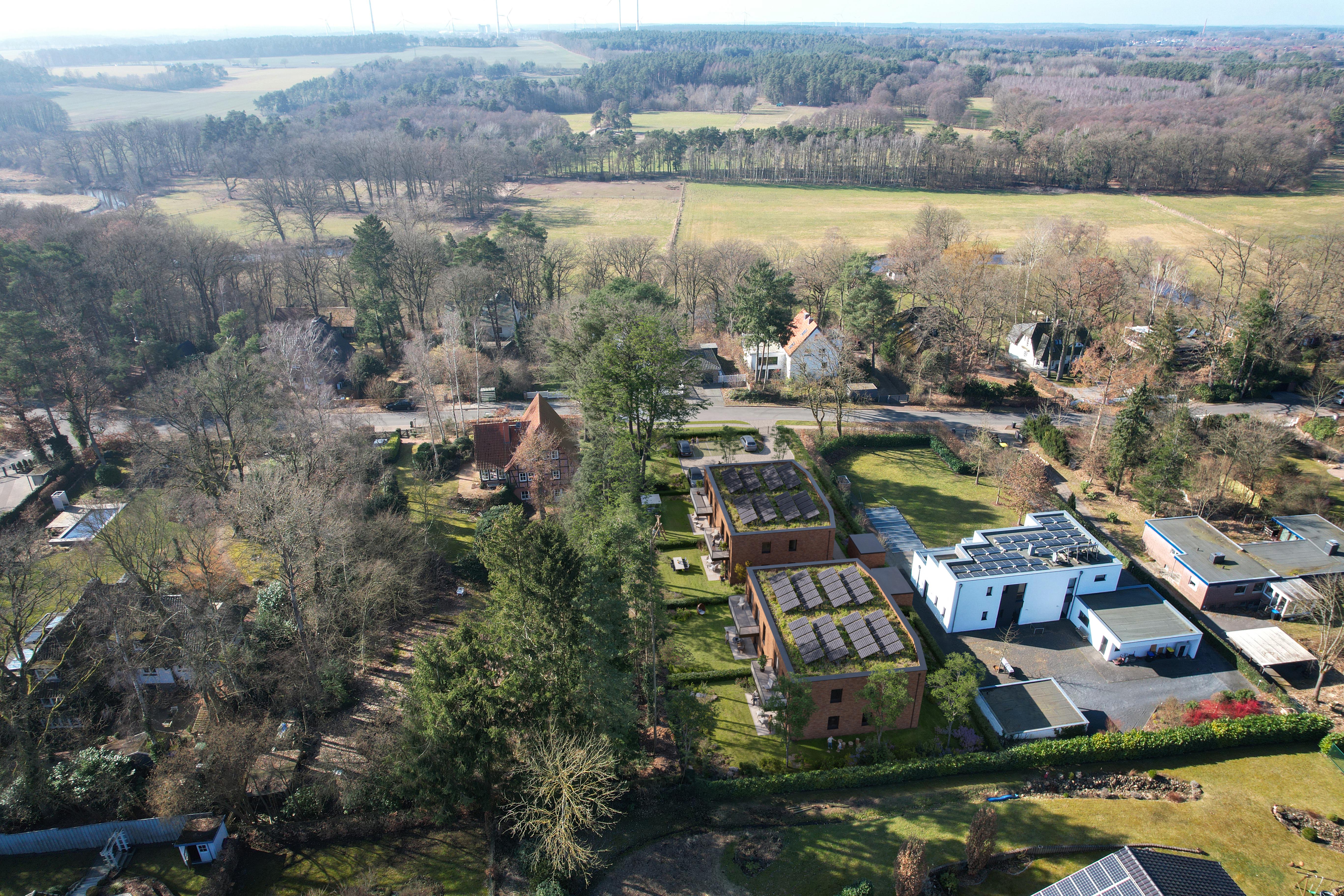Aerial view of Wohnen am Petersberg in Deutsch Evern with two brick buildings, planted roofs, and solar panels